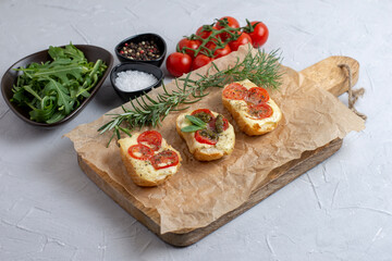Bruschetta with tomatoes, mozzarella cheese and basil on a cutting board. Traditional italian appetizer or snack, antipasto