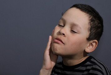 boy with toothache in pain on grey background stock photo