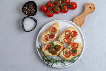 Fototapeta na wymiar Italian bruschetta with roasted tomatoes, mozzarella cheese and herbs 