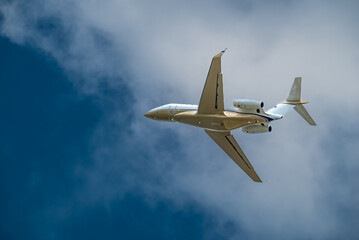 Airplane Jet flying overhead against blue sky and white clouds
