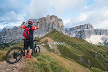 Man  on cycling electric  rides mountain trail. Man riding on bike in Dolomites mountains...