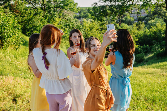 Summer party, Outdoor Gathering with friends. Five young women, Friends at the picnic dancing and having fun on summer vacation. Group of female friends enjoying at outdoors party on nature.