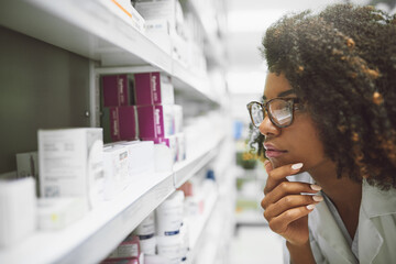 This little guy seems to be lost. Shot of a focused young female pharmacist looking closely at...