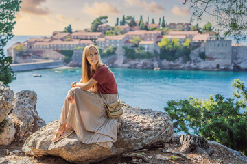 Woman tourist on background of beautiful view of the island of St. Stephen, Sveti Stefan on the...