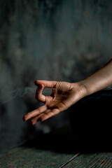 Meditation practice, hands puffed in om tonk mudra jet of incense smoke.  Close up