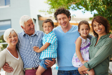 Theyre a close-knit family. Shot of a happy multi-generational family standing together outside.