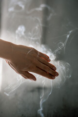 Meditation practice, hands puffed in  in smoke and rays of light. meditation practice, prayer