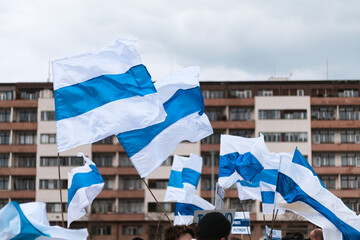 Russian new opposition white-blue-white stripped flag waving in concert for Ukraine in Prague, Czechia.