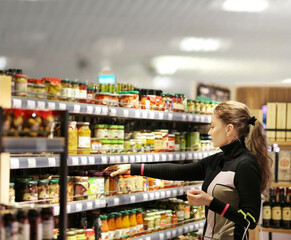 Woman choosing frozen food from a supermarket freezer.choosing a dairy products at supermarket.