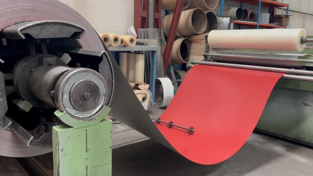 4K video of a metal company's cutting machine at work cutting a red galvanized pre-painted sheet metal. metalworking industry