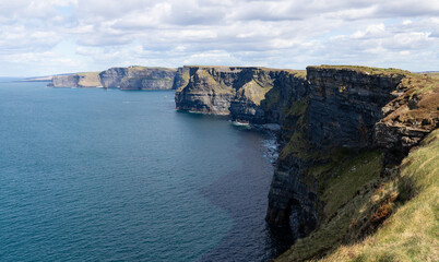 Fototapeta na wymiar Irish cliffs on a sunny day. Cliffs of Moher tourist attraction in Ireland.