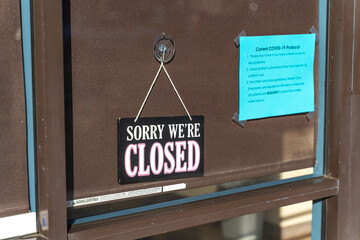 "Sorry we're closed" sign board hanging on the door.  