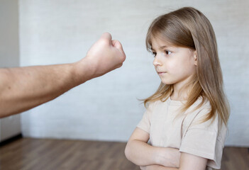 Domestic violence concept. Father  shouting at his child. Unrecognizable  man threatening daughter...