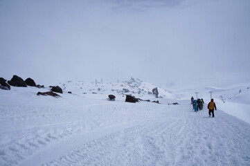 Group of backpackers going down the mountain through blizzard