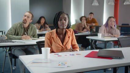 Students are sitting in the classroom and the teacher is listening the student's answer, slow motion