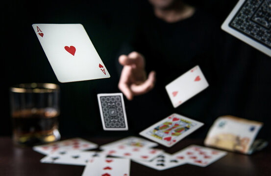 Man throwing playing poker cards, gambling concept