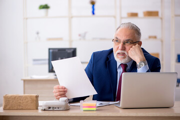 Old male employee working in the office