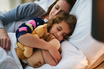 Safe and snug. Cropped shot of a mother and daughter sleeping together in bed.