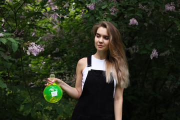 Mysterious young lady witch with round flask in her hand.