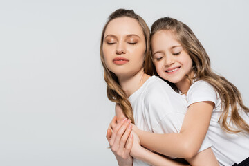 happy girl with long hair embracing mother isolated on grey.