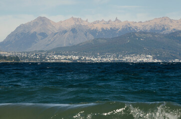 nahuel huapi lake, coast of the lake with a view of san carlos de bariloche from dina huapi with frey refuge, and cordon del cathedral in the background