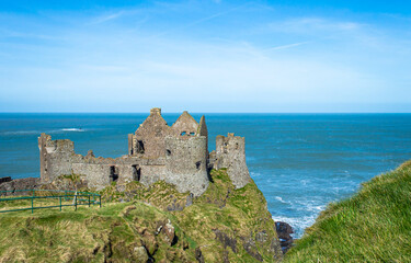 Fototapeta na wymiar Famous Dunluce Castle in Northern Ireland with blue sea background in a sunny day.