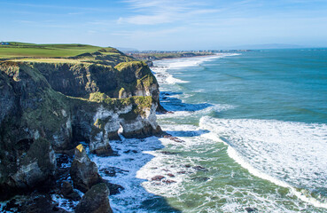 Famous white rocks at the coastline near Portrush Northern Ireland in a sunny day.