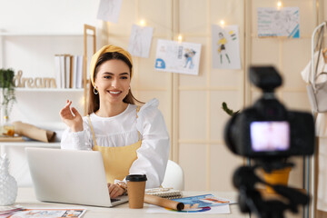 Young female clothes stylist recording video in studio