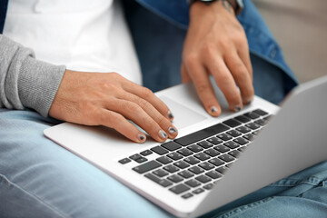 Man with trendy manicure using laptop, closeup