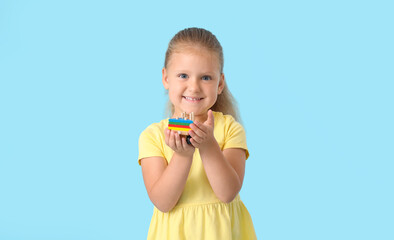 Cute little girl with building blocks on blue background