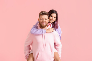 Cool young couple in hoodies on color background