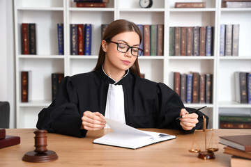 Female judge working at table in courtroom