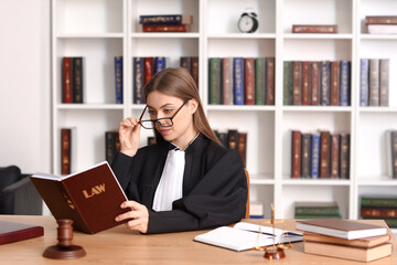 Female judge with book at workplace in courtroom