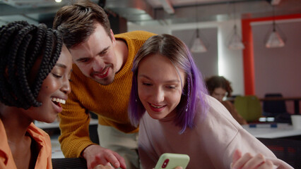 During breaking time, students are showing to their professor a funny video and they are laughing together, slow motion close up
