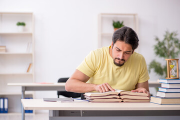Young male student preparing for exams in time management concep