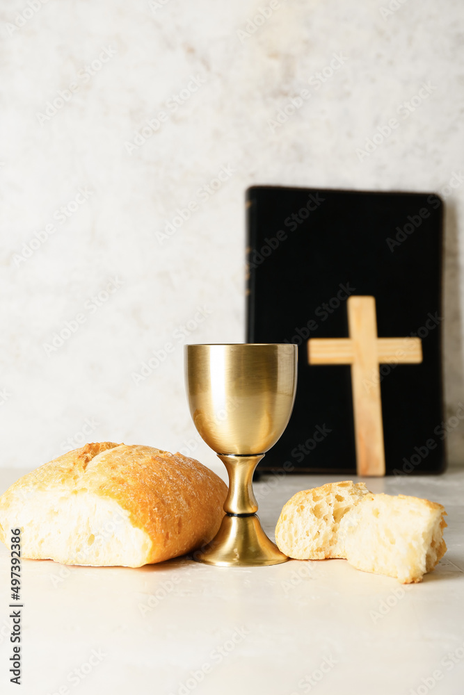 Wall mural cup of wine with bread, holy bible and cross on light background