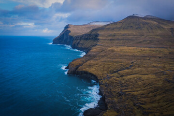 Fototapeta premium Steep coast of the islands of Eidi on Streymoy Island. Volcanic archipelago in the Atlantic Ocean, Faroe Islands. November 2021