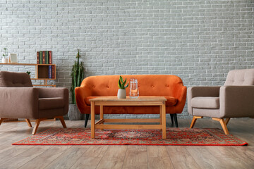 Interior of cozy living room with vintage carpet, sofa and armchairs