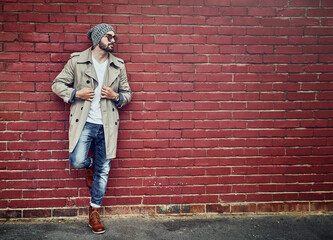 Style that appeals to the urban man. Shot of a fashionable young man wearing urban wear and posing against a brick wall.