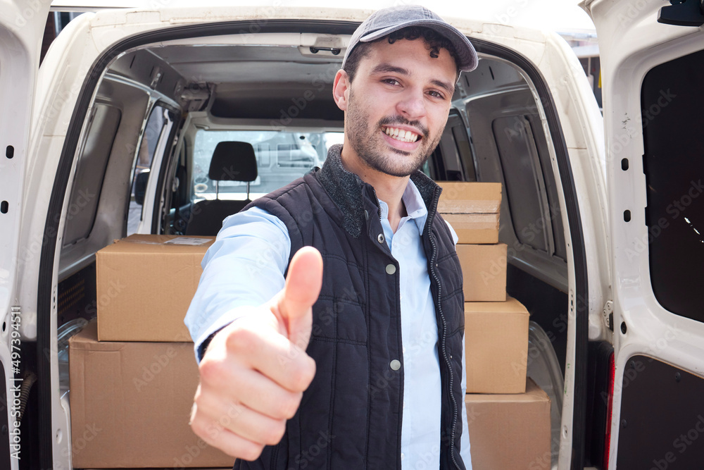 Poster quality service is my promise to you. portrait of a young delivery man showing thumbs up while loadi