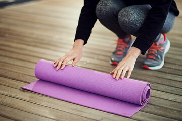Yoga class was good...as always. Cropped shot of an unrecognizable woman rolling her mat up after yoga.