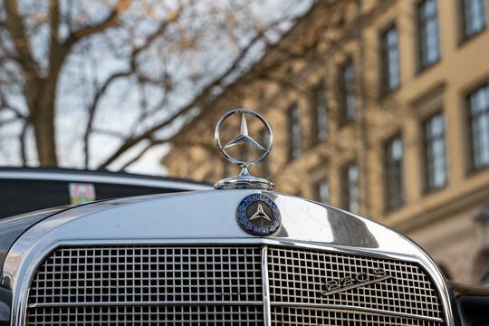 DRESDEN, GERMANY - 31. March 2021: Mercedes-Benz W111 220 S front emblem of a black car. Classic german car with a shiny chrome front grill and a radiator mascot