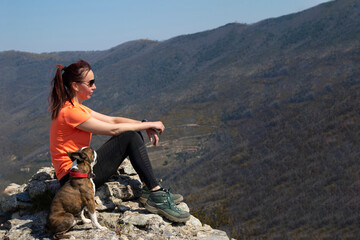 trekking woman with Boston terrier on  looks into the distance