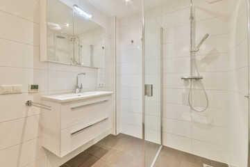 Design of a modern bathroom with a glass shower and sink in a modern house