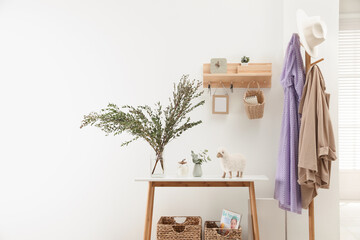 Wooden clothes rack and key holder on white wall in hallway
