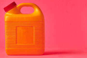 Yellow plastic bottle for mezcal on a pink background. Traditional container for storing liquids.