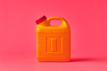 Yellow plastic bottle for mezcal on a pink background. Traditional container for storing liquids.