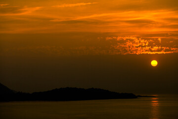 The background of the sea by the evening sea, with natural beauty (sea water, rocks, sky) and fishermen are fishing by the river bank, is a pleasure during travel.