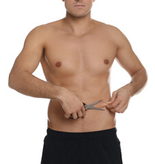 Fit man with scissors on white background, closeup. Weight loss surgery