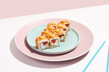 Alternative maki roll with chicken on coloured background. Sushi roll with chicken, cheese and tomato inside, bread crumbs outside. Maki sushi in minimal style. Japanese menu concept.